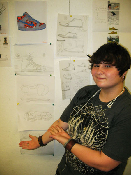 Katie showcasing her original sketches to her final signature sneaker design!